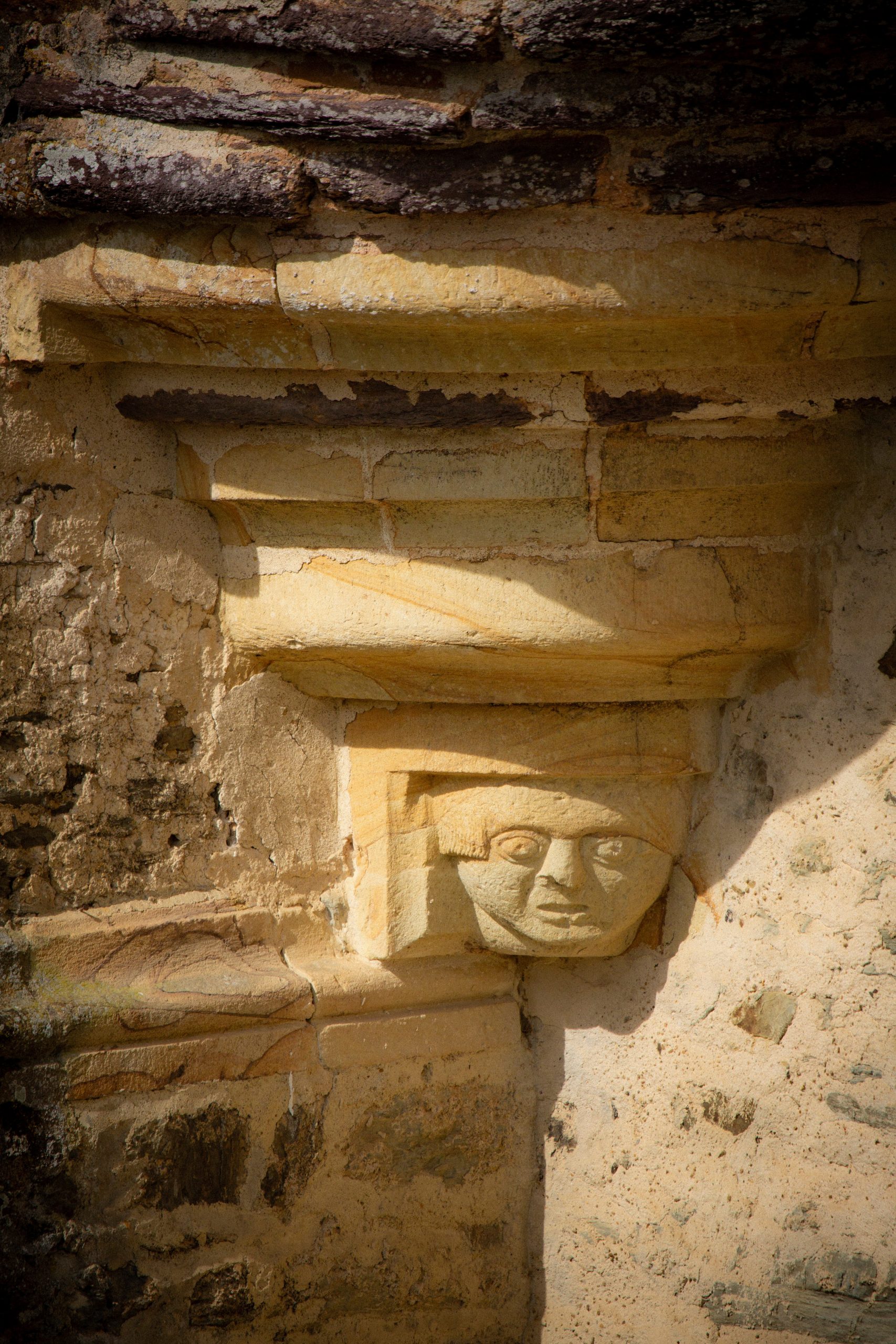 Taille de pierre : amortissement médiéval d’un bandeau en pierre, entre une tour et une échauguette