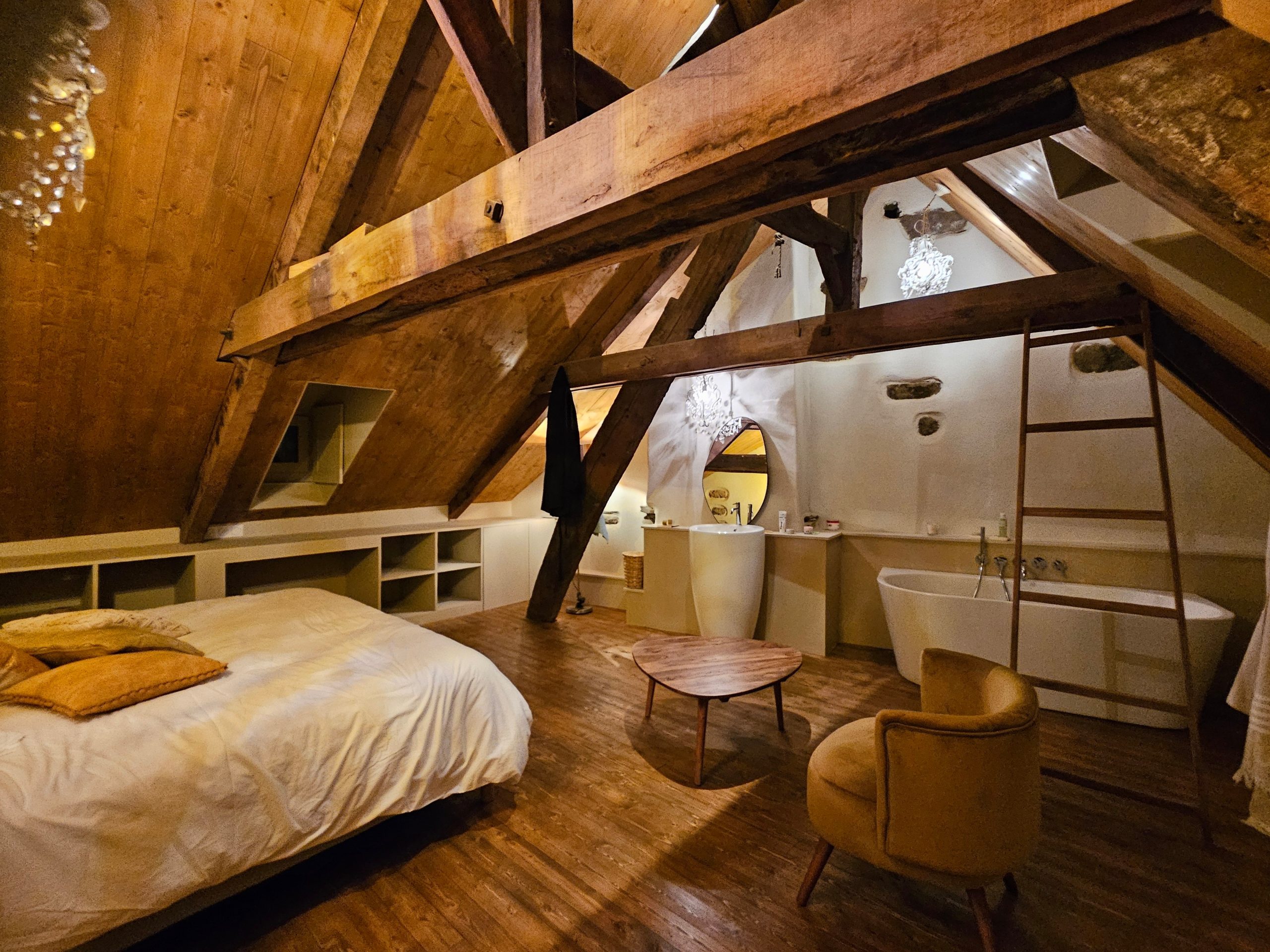 Sous les combles, un grenier métamorphosé accueille une suite magistrale avec salle de bain ouverte.